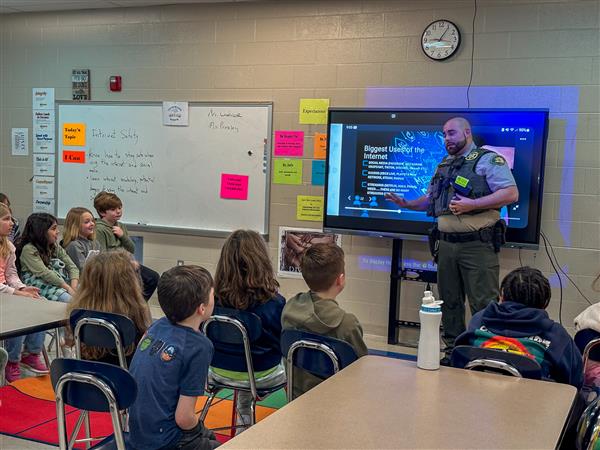 police officer talking to class of students